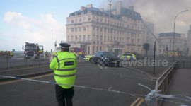 OPolice watch on as fire fighters tackle blaze at Albion Hotel which is still on Fire, Brighton, East Sussex, UK