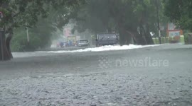 Locals and vehicles struggle through floodwater as extreme rain hits Padang