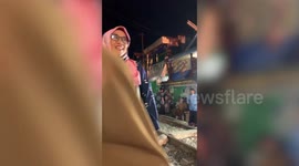 Train passes through wedding banquet held alongside railway in Indonesia