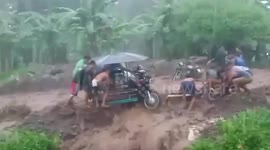 Frantic locals battle to keep raging flood from washing away vehicles in the Philippines