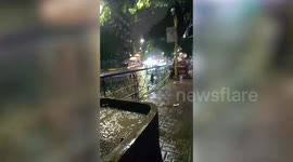 Children swim in filthy flood as monsoon storm batters the Philippines