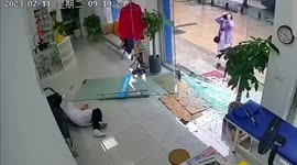 Glass door falls onto doctor as woman pushes it open in a Chinese clinic