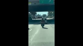 Man on Motorcycle with a Rifle