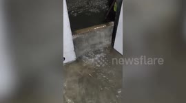 Residents scoop out filthy knee-deep flood flowing into homes during Philippines storm