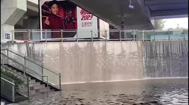 Torrential rain transforms railway station exit into a cascading waterfall in China