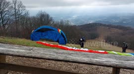Paragliders taking of from beutiful mountain before storm in clouds!