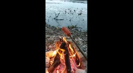 Grilling diamond sausages on bonfire near the lake, ultimate chill.