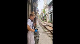 UK couple dangerously stands by rail track as train passes on Hanoi's famous street