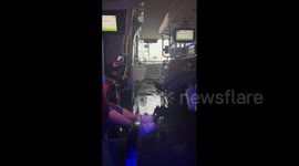 Passengers lift their feet as floodwater flows into bus in Ontario, Canada