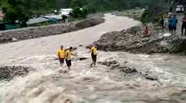 Indian SDRF forces rescuers and locals form human chain to save residents amid devastating floods in Uttarakhand