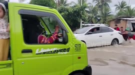 Locals push vehicles through heavy flood caused by Super Typhoon Doksuri