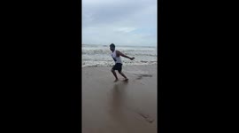 Confident beachgoer's back handspring attempt meets a slippery setback
