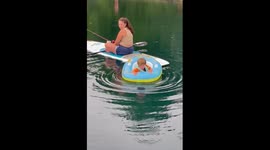 Women fishing with her toddler in the middle of the pond catches a fish