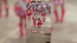 Energetic schoolgirl stands out in parade with her dance move