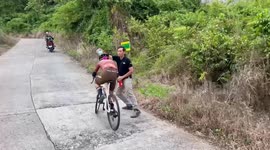 Supportive father pours water over his cyclist son during bike race