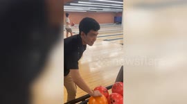 Youngster falls over while playing ten pin bowling