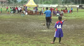 Talented little boy disturbed by a muddy field in a mini soccer match in Indonesia