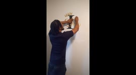 Soon to be dad decorating baby room with name logo sticker