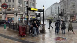 People struggle with heavy rain around Oxford circus, London, Uk