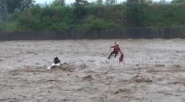 Daredevil rescue for driver trapped in middle of raging river