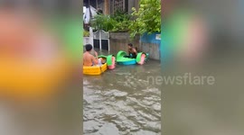 Locals play in boats on flooded road amid typhoon aftermath in the Philippines
