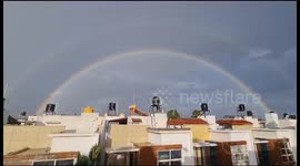Beautiful Double Rainbow in the sky as seen from the city with houses and buildings