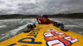 Coast guards paddle through waves to help surfers struggling with the powerful swell in Scotland