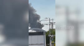 Planes pass through thick black smoke clouding flight path above burning homes