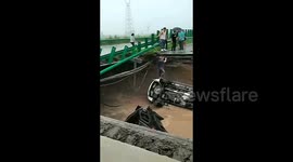 Car plunges from collapsed bridge amid torrential rain in northern China