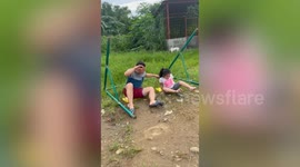 Father drags over park swing while playing with his daughter