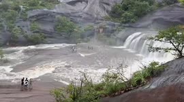 Stranded tourists rescued when flash flood surges down waterfalls during storm in Thailand