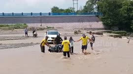 Rescue officials save biker, woman trapped in flooded path in northern India