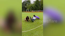 Friends suffer double slip while posing in the rain with umbrellas