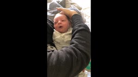 Sleepy baby passes the PUREST smile in the world when mom caresses his face