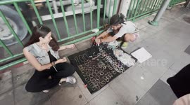 Begpackers set up stall outside subway station in Bangkok