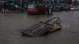 Locals balance on central reservations to navigate flooded roads in Bangladesh