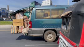 People carrier has cargo spilling from the back on busy road