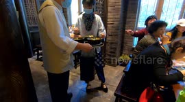 A waiter at a Nanjing food stall in Nanjing, Jiangsu Province serves duck blood and vermicelli soup to diners