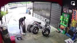 Car wheel rolls out of repair garage and into busy road