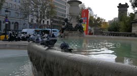 Pigeons are taking a majestic bath in a beautiful fountain in Barcelona on a hot day in the city center