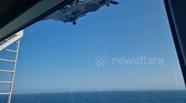 Passengers on Royal Caribbean cruise ship watch helicopter medivac crew member at sea