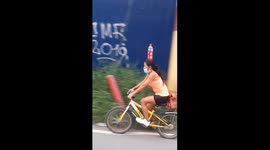 Bicyclist Balances Bottle on Head