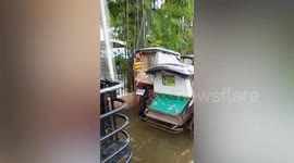 Driver lengthens tuktuk to ride through flooded road