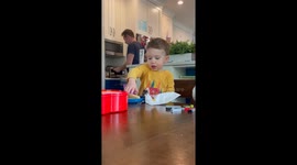 Toddler laughs heartily when father burns himself taking food out of the oven
