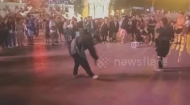 Men perform circling dances and blow trumpets on the street