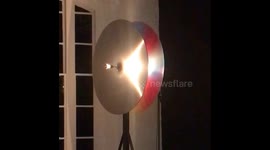 An installation of a colourful spinning circular art piece in a gallery