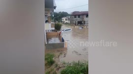Car floats in flood as monsoon rains hammer neighbourhood in the Philippines