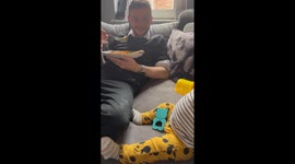 Teething baby turns into a mini dinosaur and gives his dad's leg a toothy kiss