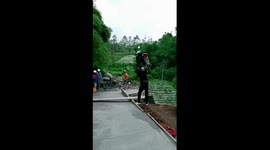Ingenuity in action: friend carries motorbike across wooden plank amid road repair obstacle