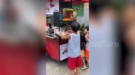 Locals play computer games on awesome modified food cart